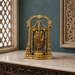 An ornate gold-toned Hindu deity statue of Lakshmi displayed on a marble console table in a decorated room with a dark teal wall and carved wooden details.