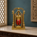 An ornate gold-toned decorative statue of a seated figure framed within an arched structure, with a red draped lower garment, displayed on a marble surface against a dark teal wall.