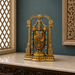 An ornate gold-toned Hindu deity statue, likely Lakshmi, displayed on a polished marble console table against a dark teal wall. The statue is decorated with intricate gold jewelry, red garments, and rows of turquoise and white beads, framed by decorative pillars.