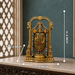 An ornate gold-toned Hindu deity statue displayed on a marble surface against a dark teal wall, with white dimension lines and text showing its measurements: 8 inches high, 5.5 inches long, and 2.