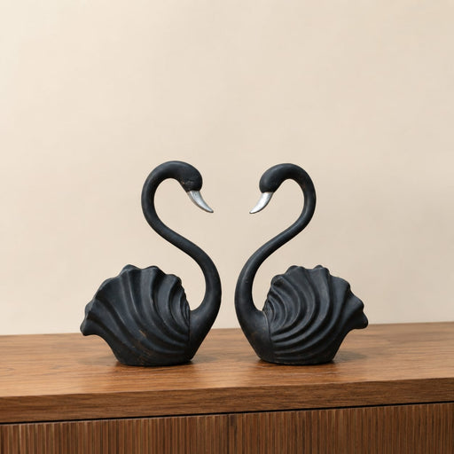 A close-up detail shot of the Black Swan Pair Figurine focusing on the artisanal carving and rich color.