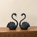 A close-up detail shot of the Black Swan Pair Figurine focusing on the artisanal carving and rich color.