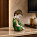 A side profile view of the Green Little Buddha Figurine revealing its graceful silhouette.