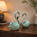 A close-up detail shot of the Green Swan Pair Figurine focusing on the artisanal carving and rich color.