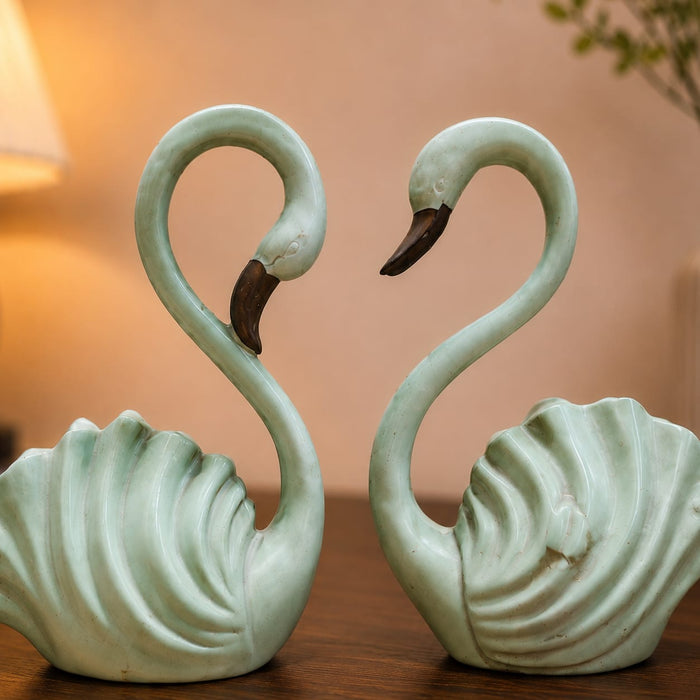 A side profile view of the Green Swan Pair Figurine revealing its graceful silhouette.