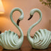 A side profile view of the Green Swan Pair Figurine revealing its graceful silhouette.