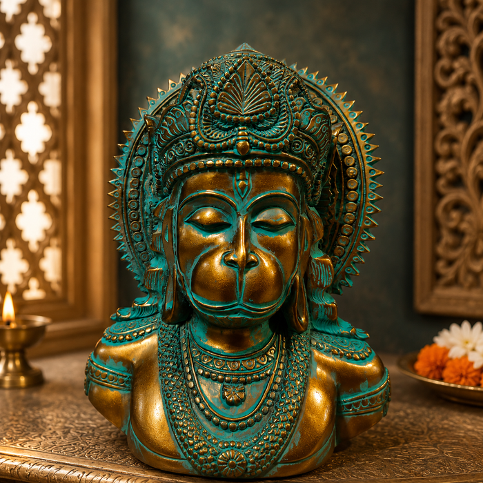 An ornate bronze and turquoise-green bust sculpture of a deity with a human face and decorative crown, displayed on a carved surface in a styled interior setting.