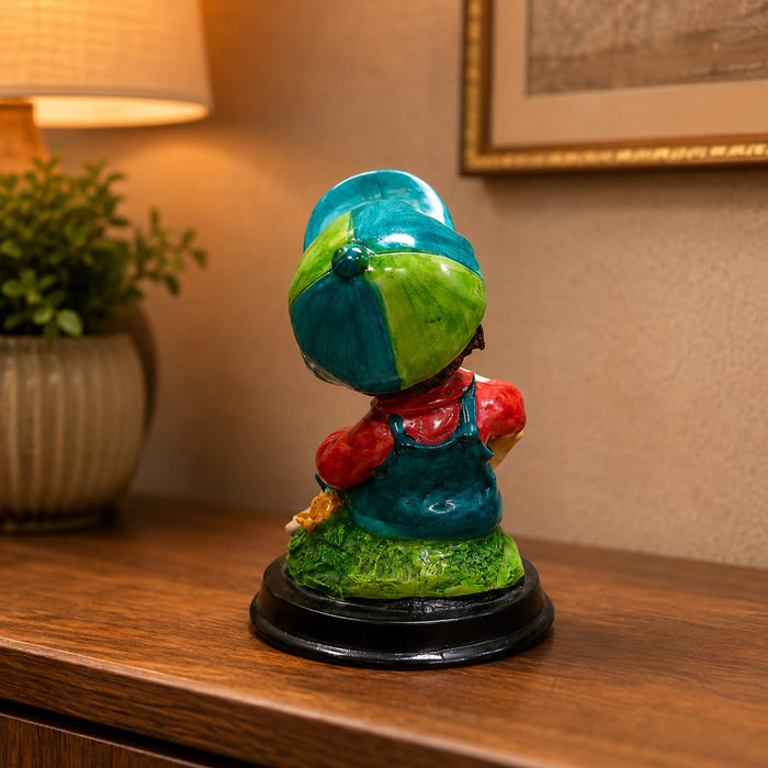 An angled perspective of the Multicolour Reading Boy Figurine highlighting its elegant three-dimensional form and craftsmanship.