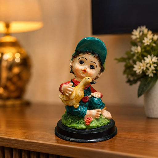 A close-up detail shot of the Multicolour Reading Boy Figurine focusing on the artisanal carving and rich color.