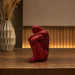 A side profile view of the Red Abstract Yoga Figurine revealing its graceful silhouette.