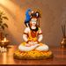 Front view of meditating Shiva idol in a warm pooja setting