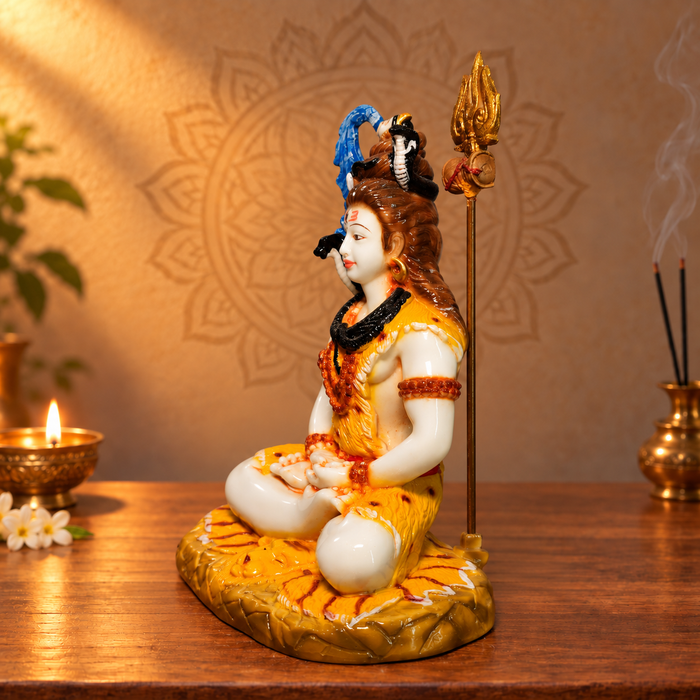 Left-facing side view of marble-dust Shiva idol with trident