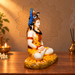 Right-facing side view of marble-dust Shiva idol in the same pooja setting