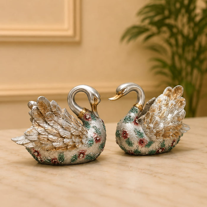 A close-up detail shot of the Silver Floral Swan Pair focusing on the artisanal carving and rich color.