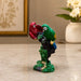 Side profile perspective showcasing elegant three-dimensional contours and sculptural depth of Vibrant Red and Green Macaw Parrots Resin Figurine (8.2 Inch)
