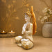 A side profile view of the White and Gold Buddha Idol revealing its graceful silhouette.