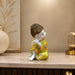 The detailed back view of the Yellow Little Buddha Figurine showing the intricate texture of the material.